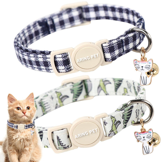Two patterned cat collars with bells and engraved nameplates, with orange cat wearing one