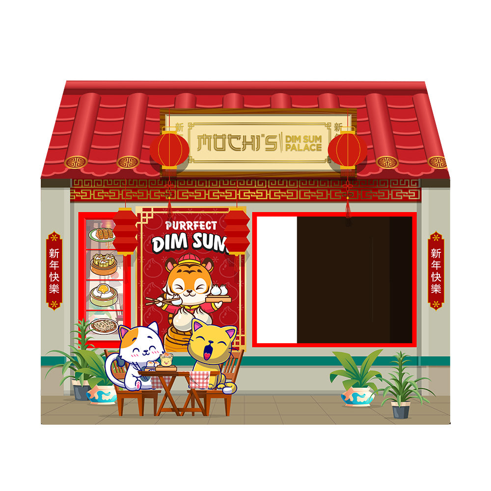 Front view of a cardboard cat house designed as a festive Asian market stall, featuring a red roof, colorful printed decorations of lanterns and a character in traditional attire, with a large rectangular entrance on the right