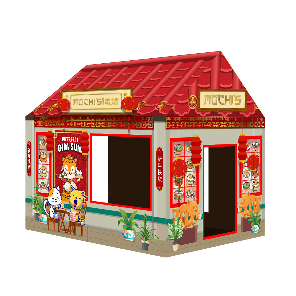 Front angled view of a colorful cardboard cat house styled like a traditional Asian market shop, featuring a red sloped roof, golden signboards, printed decorative pillars, shelves with illustrated items, and two open doorways